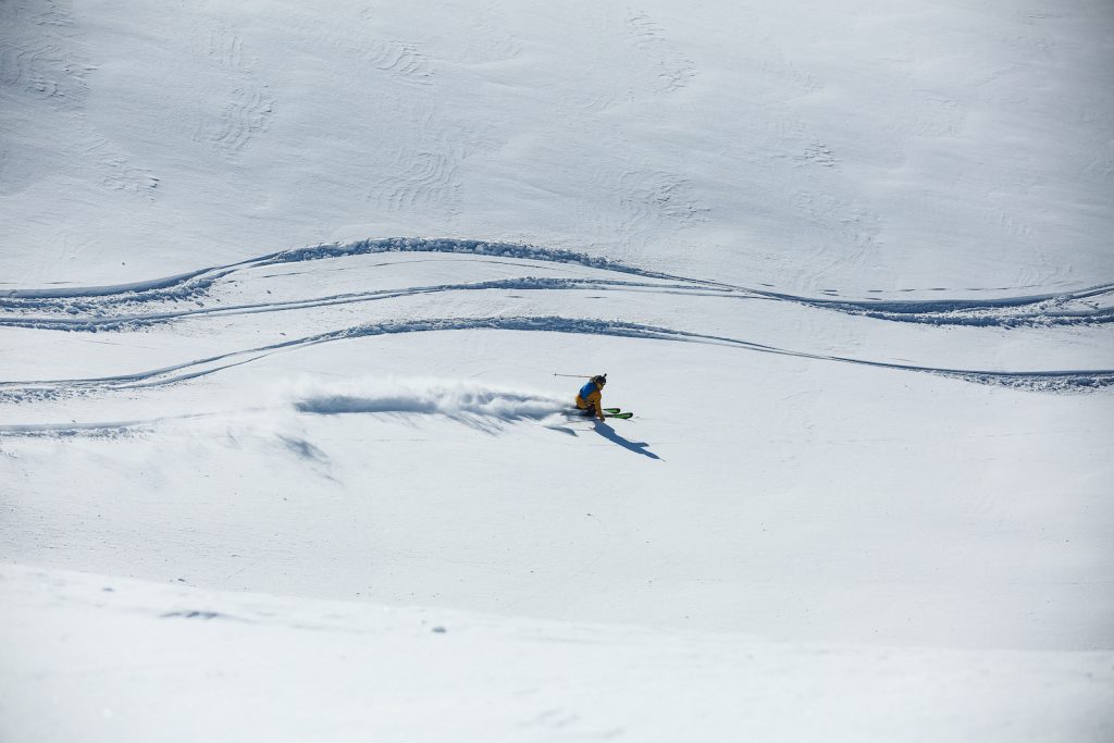 Skier in an open powder field heliskiing in British Columbia. 