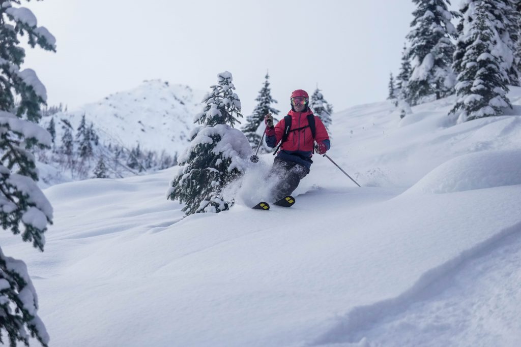 Skier enjoying powder turns at Great Canadian Heli Skiing near Golden, BC. 