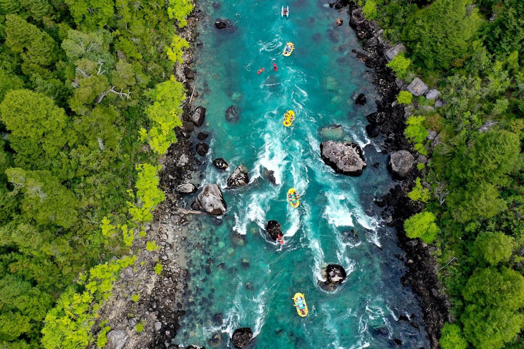 A bird's eye view of rafts floating on a river.