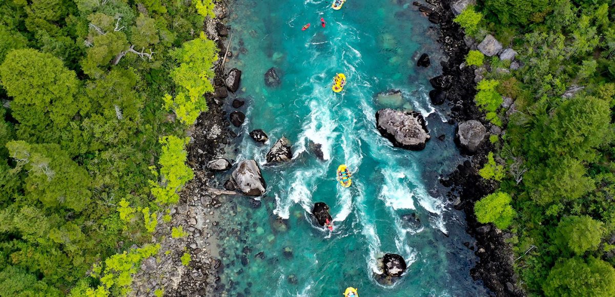 A bird's eye view of rafts floating on a river.