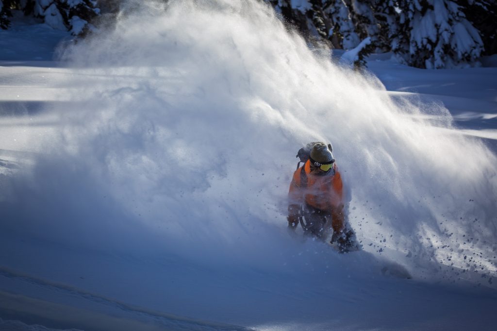 Snowboarder slashing through powder snow